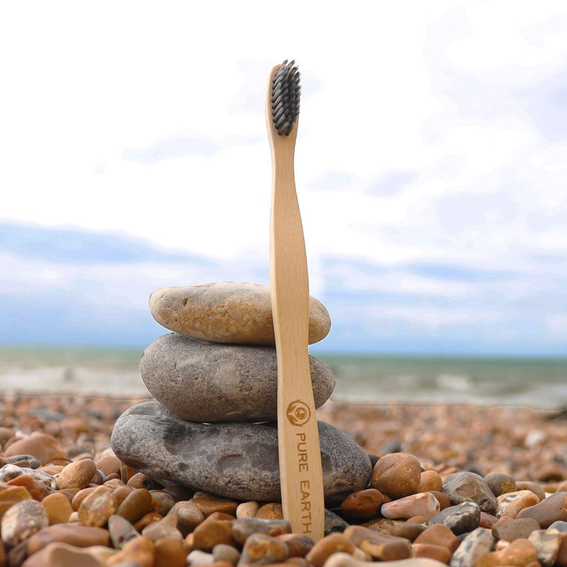 Charcoal bamboo toothbrush on rocks
